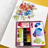 An open Pocket Palette filled with bright paints and mixes.